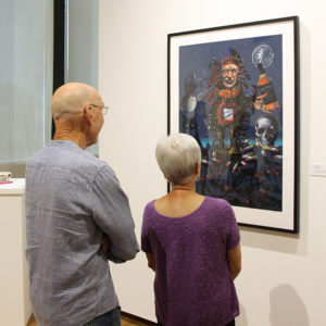 An older couple examines an artwork
