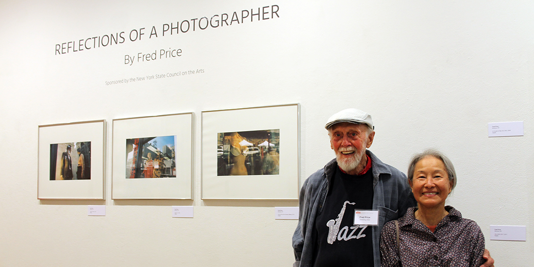 Fred Price and his wife, Faye, stand in front of three images from Fred's exhibit