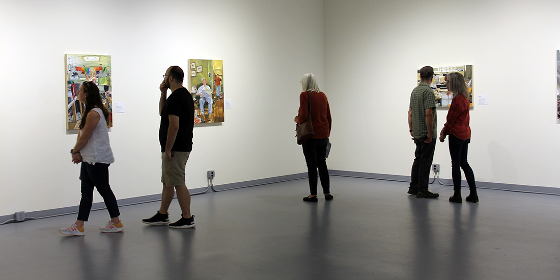 Five people in a gallery looking at detailed paintings of people