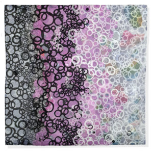 An art quilt showing circles shifting from black to pink to gray